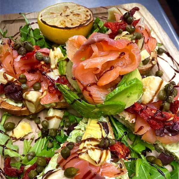 Brunch House 1850's salmon and avocado toast with capers, sun-dried tomatoes, and grilled lemon.
